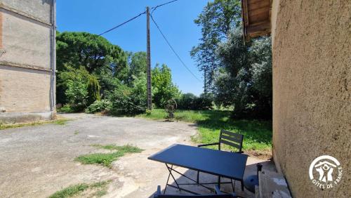 a table and a bench sitting outside of a building at Le chinchilla in Gaillac