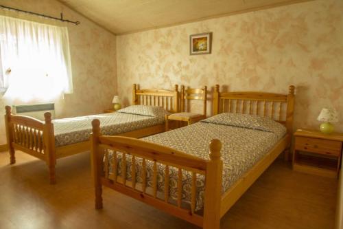 une chambre avec deux lits et une fenêtre dans l'établissement L'hermitage, à Ambres