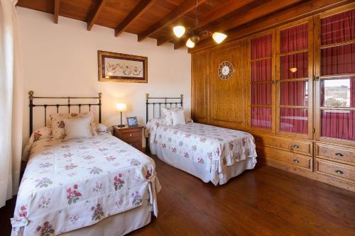 two beds in a room with wooden floors at El Islote in San Bartolomé