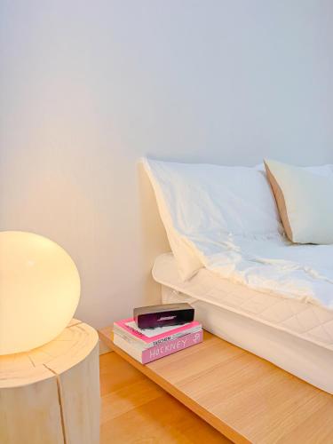a bedroom with a bed with a stack of books and a lamp at STAY ONDAM #3room #10guests in Seoul