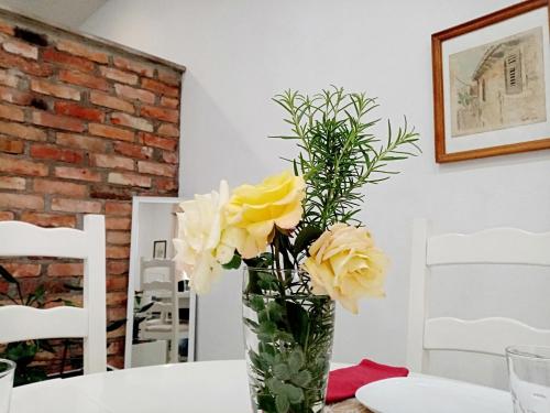 a vase filled with yellow roses sitting on a table at Sava & Double Rooms in Prijedor