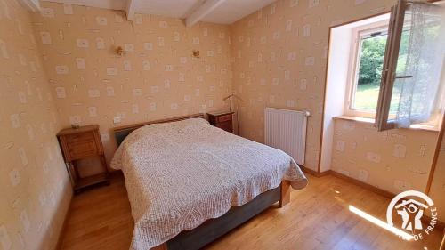 Un dormitorio con una cama y una ventana en Guyor, en Le Bez