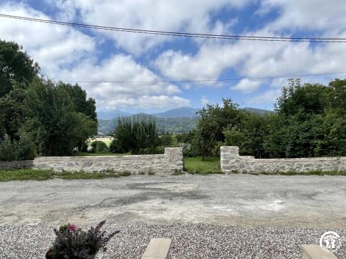 a stone wall with mountains in the background at Gite du tatou in Roquefeuil