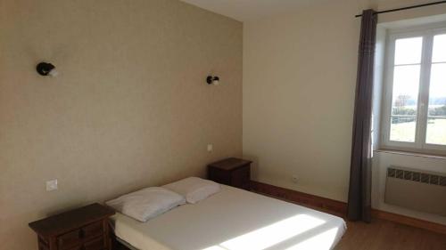 a bedroom with a white bed and a window at Le grand gite de souels in Almayrac