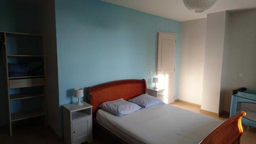 a bedroom with a bed with a blue wall at Le grand gite de souels in Almayrac