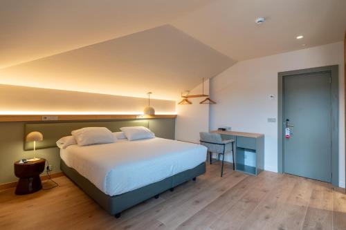 a bedroom with a large bed and a desk at Hotel Los Pasiegos in Hoznayo