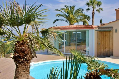 une villa avec piscine et palmiers dans l'établissement Casa SeaRock, à Théoule-sur-Mer