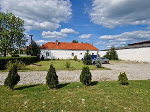 a house with a car parked in a yard at Penzion Kravín in Bošilec