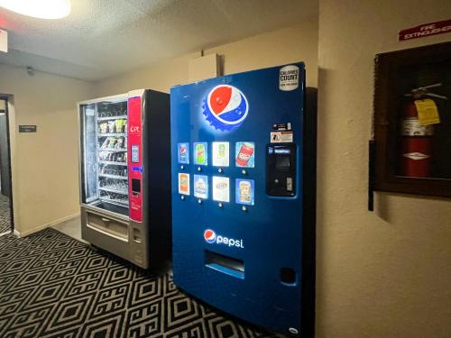 a blue vending machine is next to a refrigerator at Motel 6 Concordia in Concordia