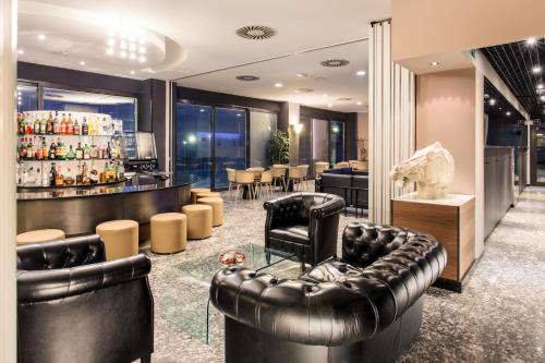 a bar with black leather furniture and a counter at Waldorf Palace Hotel in Cattolica