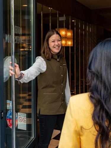 a woman standing in front of a store at Hôtel La Conversation in Paris