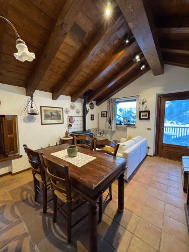 a kitchen and living room with a wooden table and chairs at L'Atelier du Temps - Casa Torre in La Salle