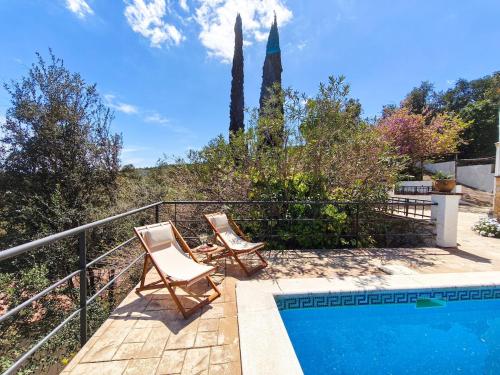 two chairs sitting next to a swimming pool at Villa Marie, 8 pers, green zone, private in GRO