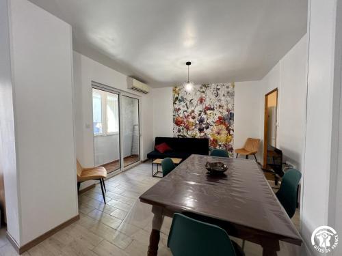 a living room with a wooden table and chairs at Chez madou in Roquefort-des-Corbières