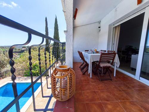 a balcony with a table and a swimming pool at Villa Marie, 8 pers, green zone, private in GRO