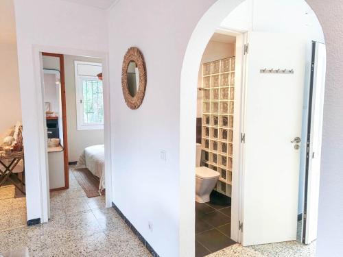 a hallway with a bathroom with a toilet and a mirror at Villa Marie, 8 pers, green zone, private in GRO