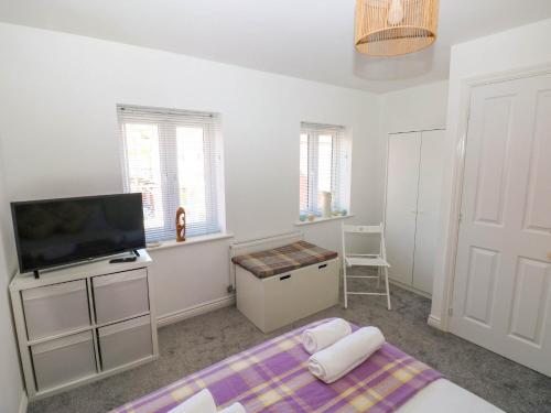 a bedroom with a bed and a flat screen tv at Ty Bach Twt Llanelli in Llanelli