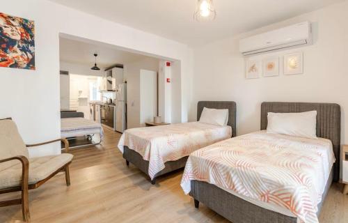 ein Hotelzimmer mit zwei Betten und einem Stuhl in der Unterkunft Güneş Villa Bahçe Katı in Antalya