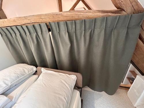 a couch in a room with a curtain at Au 8 à Meursault, Magnifique maison Bourguignonne au pied des vignes, jardin, places de parking privée in Meursault