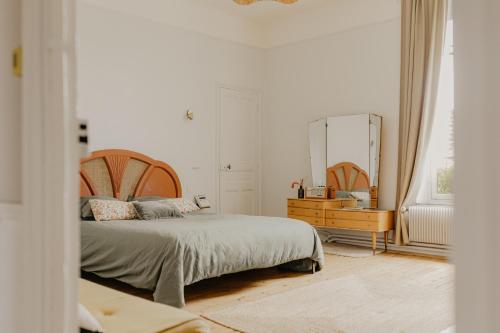 une chambre avec un lit, une commode et un miroir dans l'établissement Maison Sollier, à Sainte-Croix