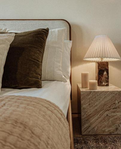 a bed with a pillow and a lamp on a night stand at Terra Palm Springs in Palm Springs