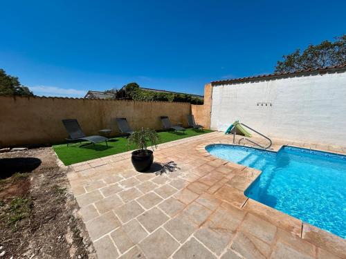 a swimming pool in a yard with chairs at Domaine des Oliviers - Les Borrels in Hyères
