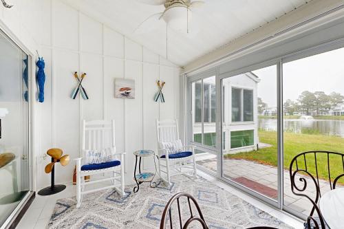 a screened in porch with chairs and a table at Mallard Lakes - 142 Cardinal in Selbyville