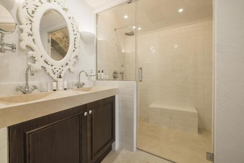 a bathroom with a sink and a shower with a mirror at Château Le Cagnard in Cagnes-sur-Mer