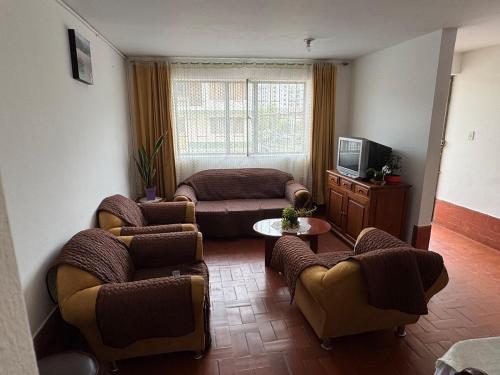 sala de estar con sillas, sofá y TV en Omar J House, en Paipa
