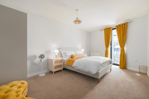 a white bedroom with a bed and a window at 1 Bedroom Apartment near City Airport in London