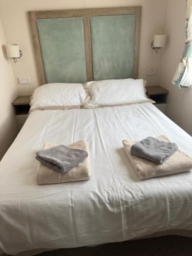 a white bed with two towels on top of it at Agnes Place in Nairn