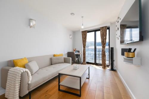 a living room with a couch and a table at 1 Bedroom Apartment near City Airport in London