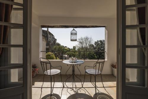 a patio with a table and chairs on a balcony at Château Le Cagnard in Cagnes-sur-Mer