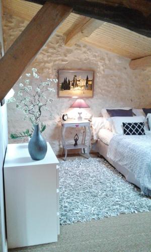 - une chambre avec un canapé et une table avec un vase dans l'établissement Le Colombier, à Villeneuve-sur-Lot