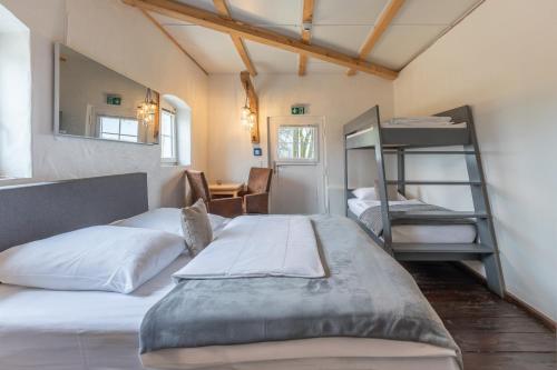 a bedroom with two bunk beds and a desk at Lodge an der Eider in Friedrichsgraben