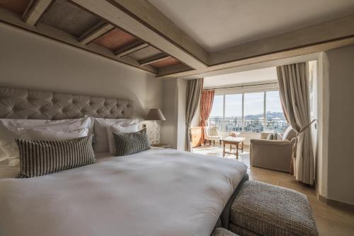 a bedroom with a large bed and a large window at Château Le Cagnard in Cagnes-sur-Mer