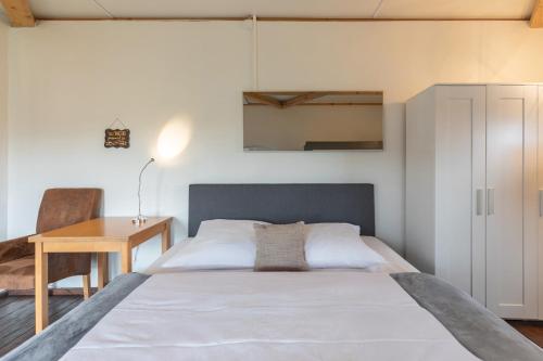 a bedroom with a bed and a desk and a table at Lodge an der Eider in Friedrichsgraben