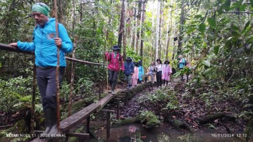 a group of people walking on a bridge in the forest at Alojamiento LETICIA in Leticia