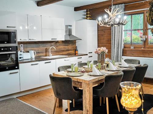 cocina con mesa de madera con sillas y comedor en Rioba Chalet, en Nová Bystrica