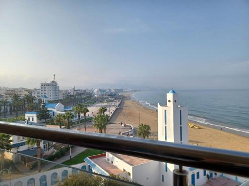 a view of a beach and the ocean from a balcony at Miramar in M'diq
