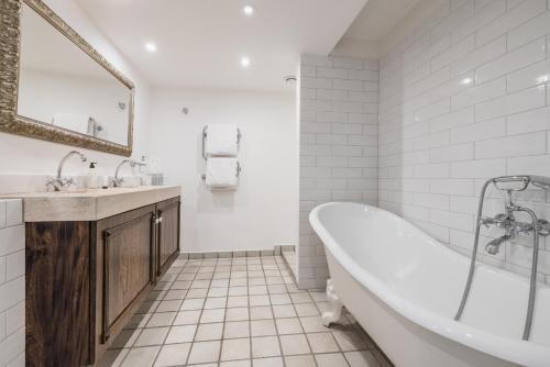 a white bathroom with a tub and a sink at Château Le Cagnard in Cagnes-sur-Mer