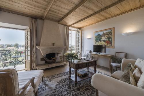 a living room with a couch and a fireplace at Château Le Cagnard in Cagnes-sur-Mer