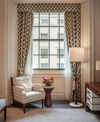 a living room with a chair and a window at Raffles London at The OWO in London