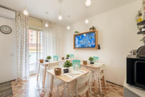 a dining room with tables and chairs and a tv at Ciccio Rooms and breakfast - Self check-in in Palermo