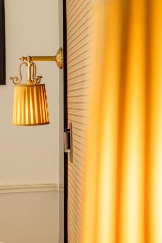 a lamp next to a door with a curtain at Hotel Observatoire Luxembourg in Paris