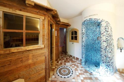 La salle de bains est pourvue d'une douche en verre. dans l'établissement Alpenhotel Panorama, à Campitello di Fassa