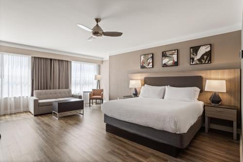 a hotel room with a bed and a chair at Holiday Inn Baton Rouge College Drive I-10 by IHG in Baton Rouge