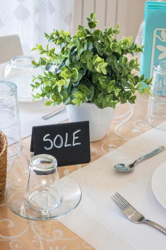 a table topped with a table sign with a potted plant at Ciccio Rooms and breakfast - Self check-in in Palermo