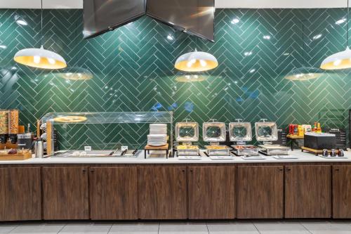 a kitchen with a counter with a green tiled wall at Holiday Inn Baton Rouge College Drive I-10 by IHG in Baton Rouge