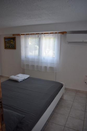 a bedroom with a large bed with a window at Traditional apartment in nature in Kouvaláta